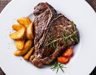 Juicy steak with a side of potatoes.