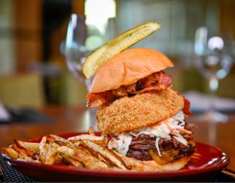 Hamburger with onion ring and pickle from VUE Grille & Bar