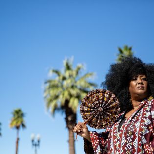 Aneka Brown with palm trees behind her