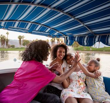 Mother and daughters on gondola on lake