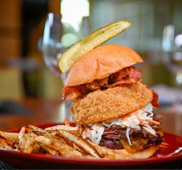 Hamburger with onion ring and pickle from VUE Grille & Bar