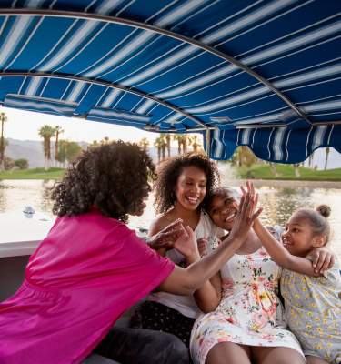 Mother and daughters on gondola on lake
