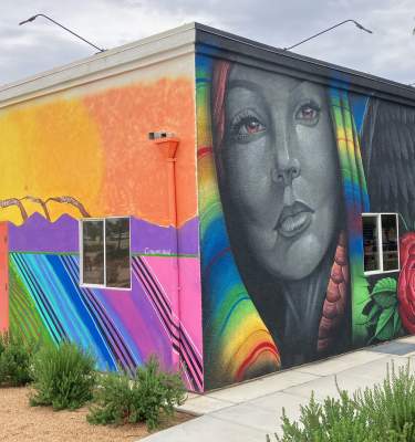 Three different colorful murals are painted on the sides of two walls at Coachella City Hall.