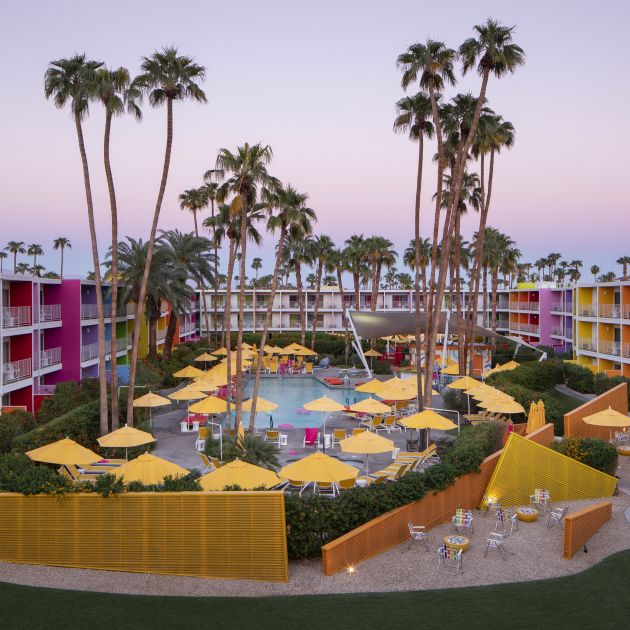 Aerial view of the pool at The Saguaro surrounded by the colorful resort buildings.