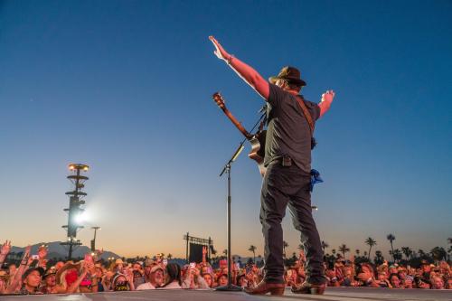 Country music star singing to large crowd at Stagecoach Music Festival.