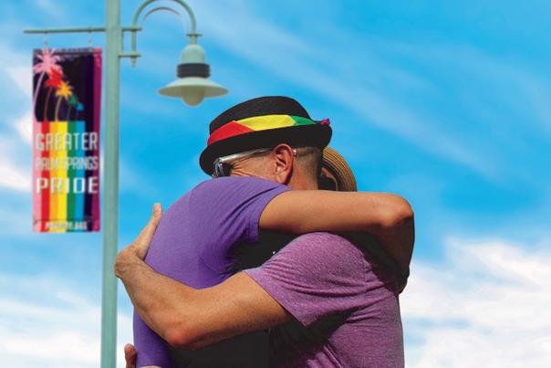 Couple hugging under GPS Pride flag