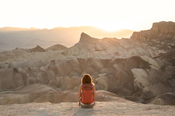 A hiker enjoying sunset at Zabriskie Point in Death Valley National Park