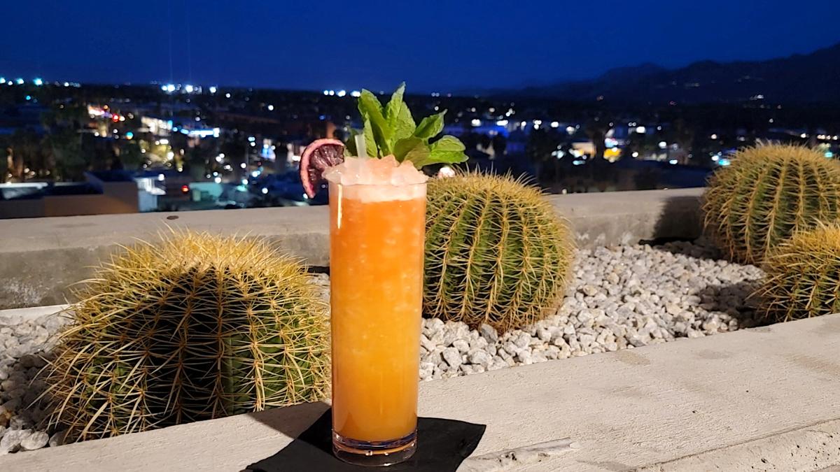 A cocktail sits on the ledge at High Bar with the Palm Springs city scape in the background.