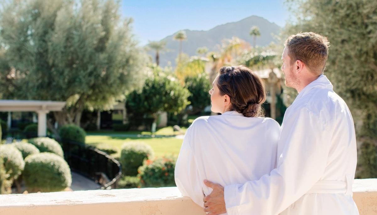 A couple enjoys the view from The Well Spa balcony