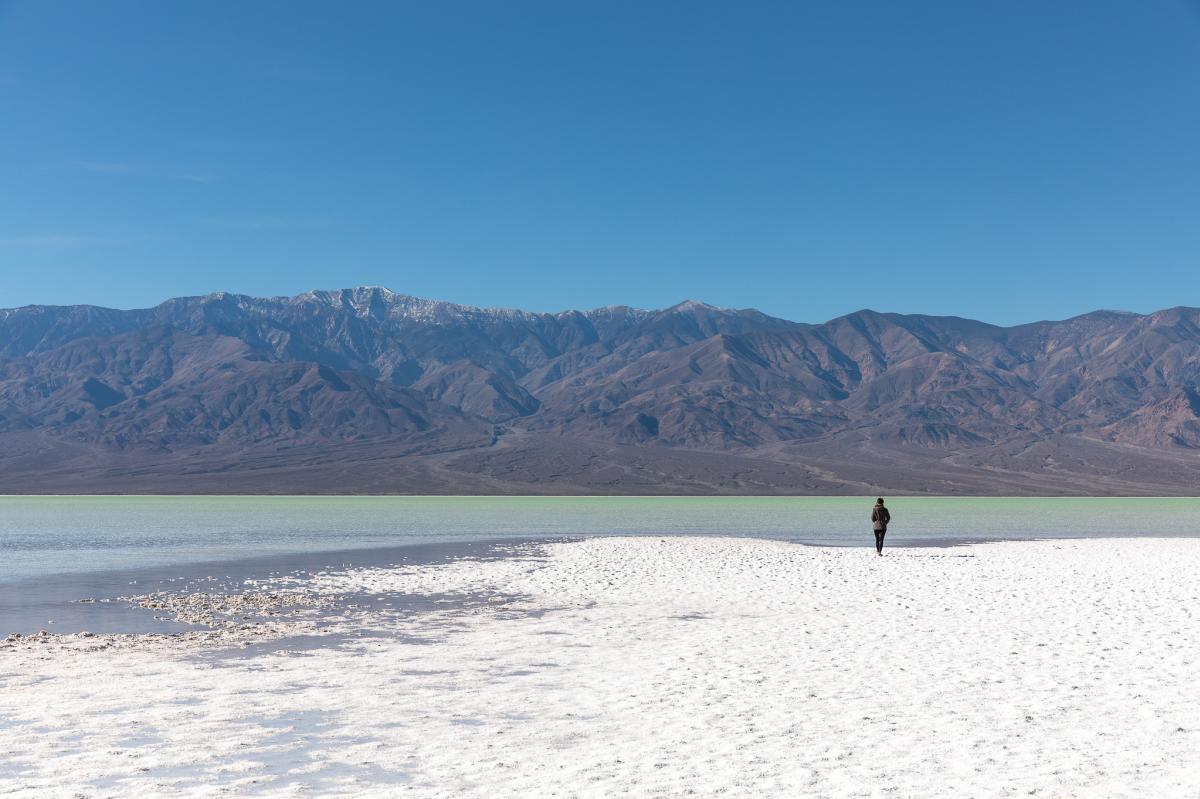 A hiker explores Lake Manly in Badwater Basin in Death Valley National Park