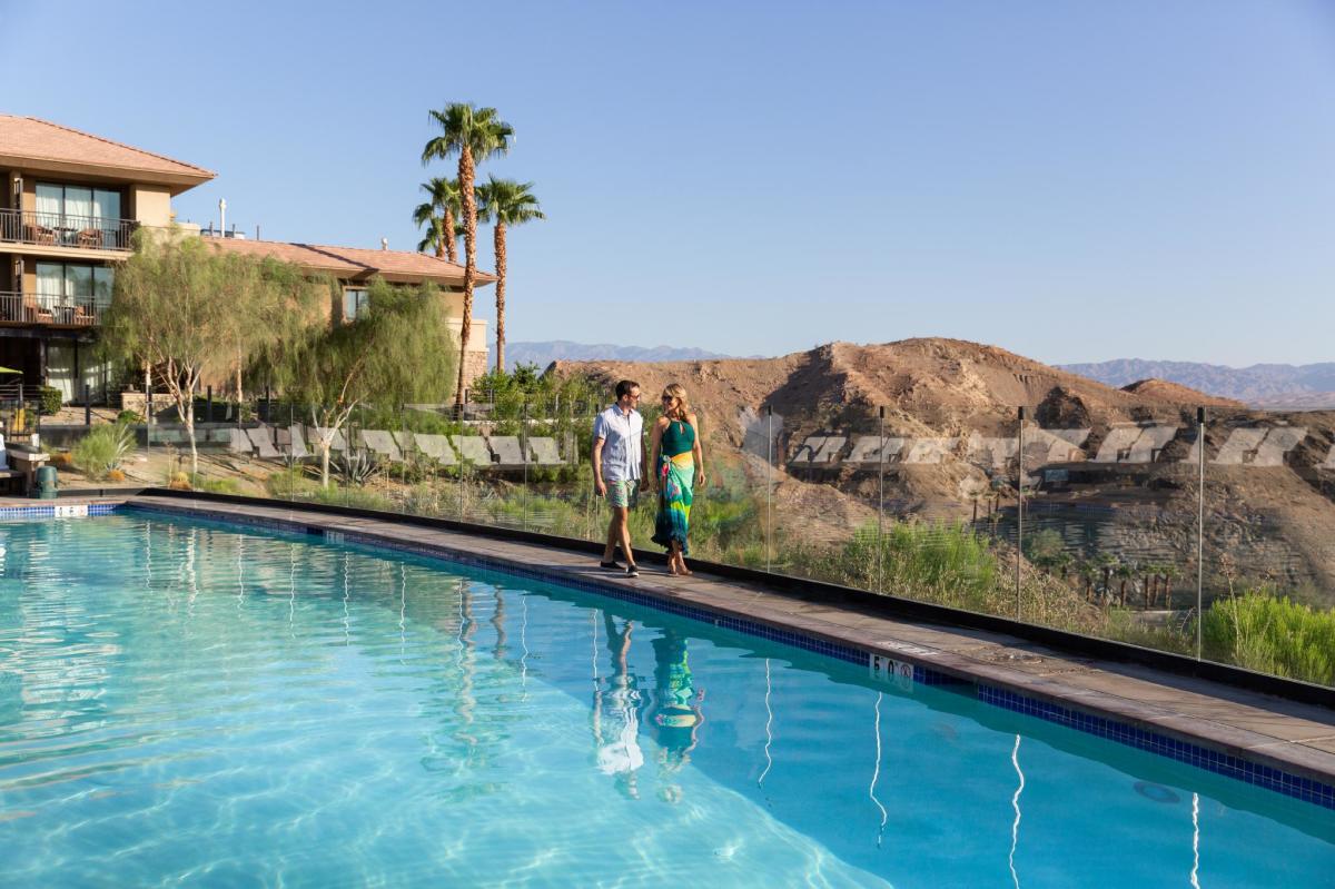 Couple walking by the pool at The Ritz-Carlton, Rancho Mirage
