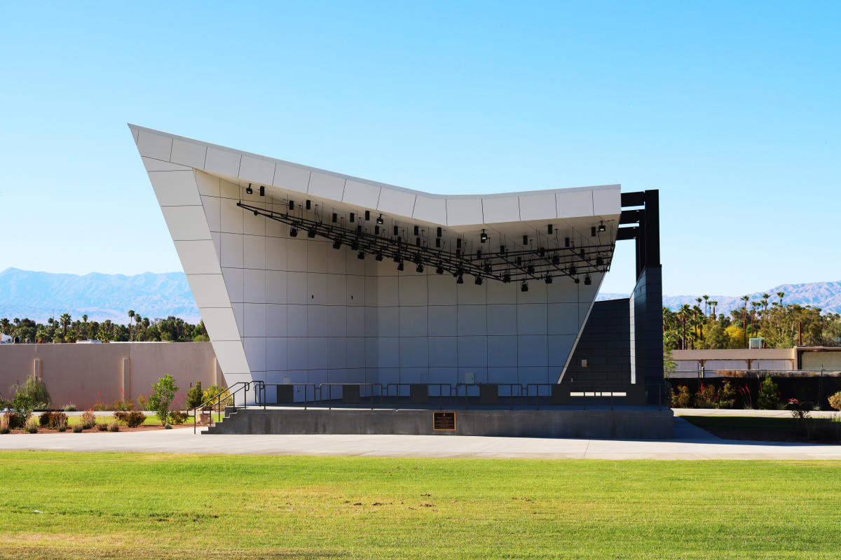 A sloped concrete stage, surrounded by a large green lawn.