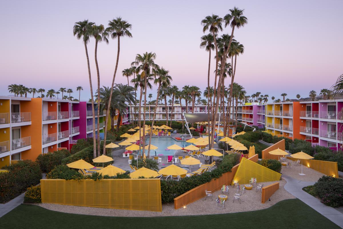 Aerial view of the pool at The Saguaro surrounded by the colorful resort buildings.