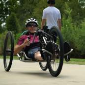 Fair skinned man using a hand cycle on the Swamp Rabbit Trail in Greenville, SC.