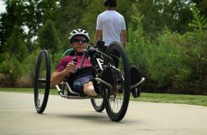 Man using a hand cycle on the Swamp Rabbit Trail in Greenville, SC.