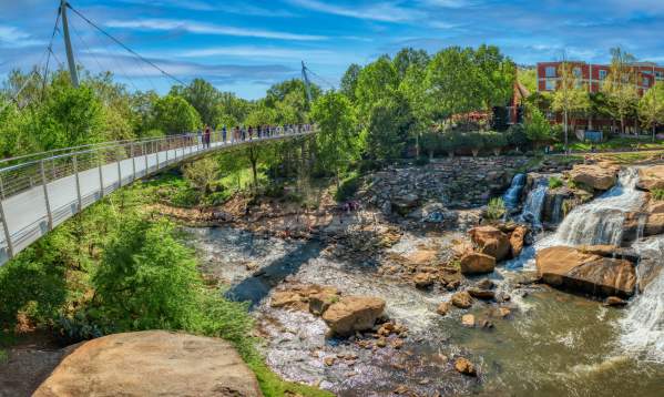 People enjoying the view of the falls from the Liberty Bridge in springtime.