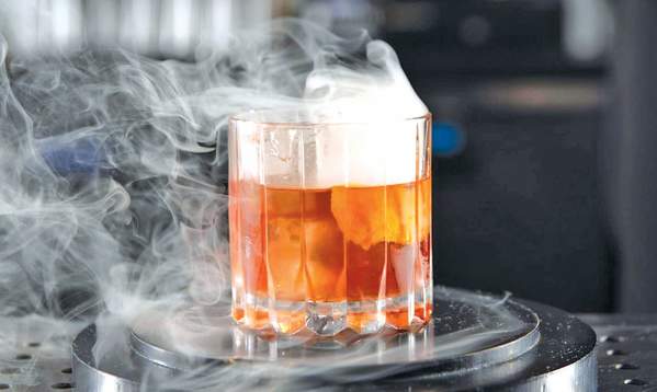Person making drink at Smoky Cocktail