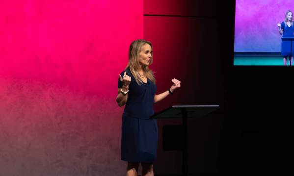 Woman speaking on stage at Jasmine Road