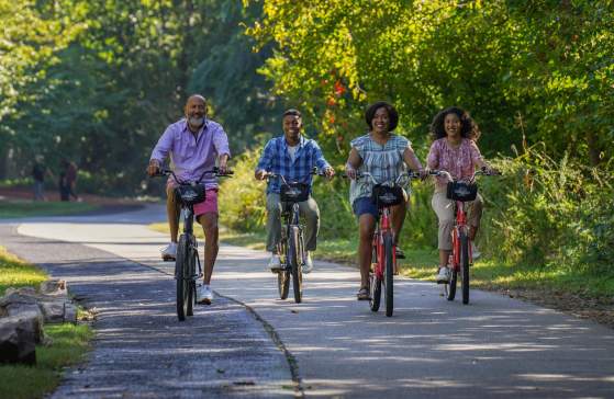 Family riding bikes on the Prisma Health Swamp Rabbit Trail Network