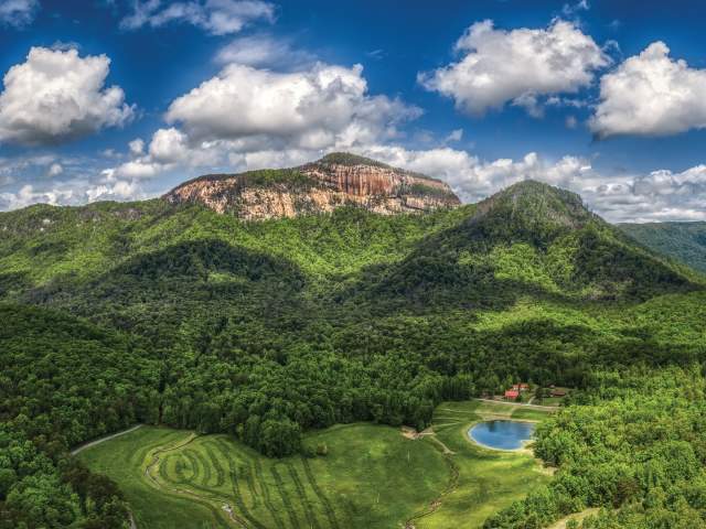 Aerial view of Table Rock State Park and the surrounding mountains and trees on a sunny day