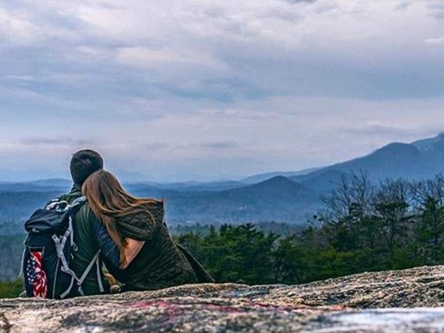 A view of a couple spending time together on Bald Rock looking out over the Blue Ridge Mountains