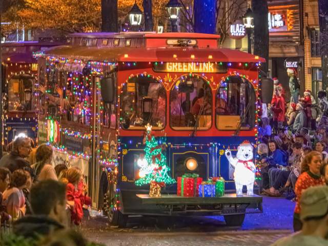 A Christmas-decorated free trolley makes its way down Main Street during the annual Poinsettia Parade held every December in Greenville, SC.