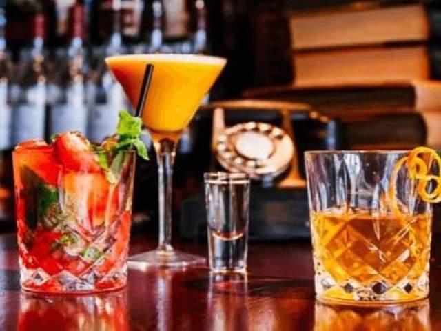 Four cocktails sit atop the bar at Neat Bourbon Bar in downtown Greenville, SC.