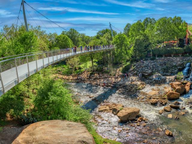 People enjoying the view of the falls from the Liberty Bridge in springtime.