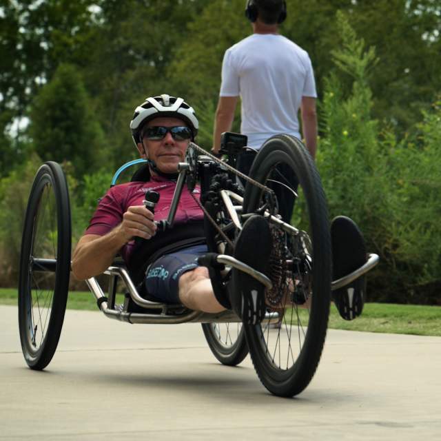 Fair skinned man using a hand cycle on the Swamp Rabbit Trail in Greenville, SC.