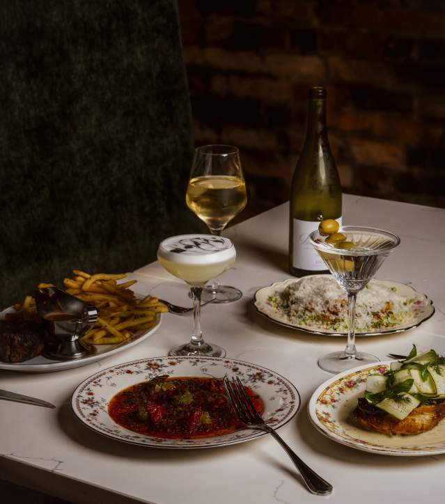 Several plated dishes and cocktails at Scoundrel
