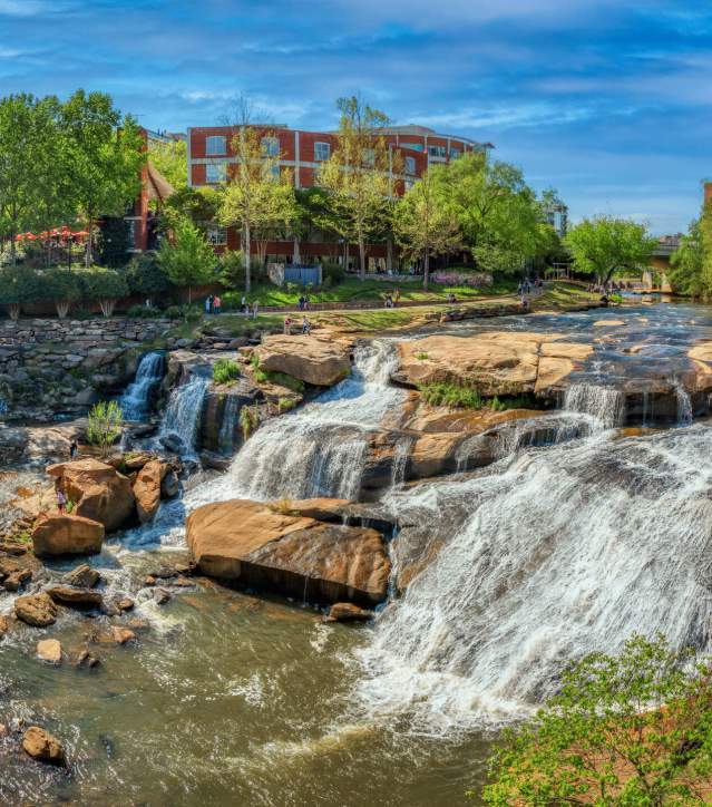 People enjoying the view of the falls from the Liberty Bridge in springtime.