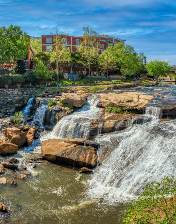 People enjoying the view of the falls from the Liberty Bridge in springtime.