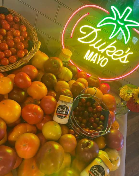 Duke's Mayo jars sit atop tomatoes of all kinds at