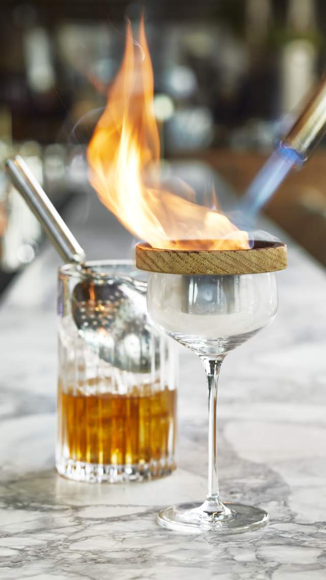 A cocktail is set on fire for display at Paloma in the AC Hotel Greenville Downtown in Greenville, SC.