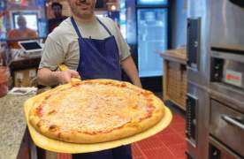 A man holding a cheese pizza