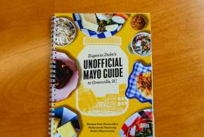 Eugenia Duke's Unofficial Mayo Guide to Greenville, SC Cookbook on a wood tabletop