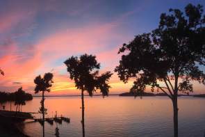 Trees sway in the breeze at sunset over the shores of Lake Hartwell in Anderson, South Carolina at Green Pond Landing & Event Center.