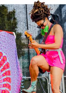 Woman playing guitar on stage.