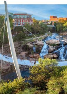 Liberty bridge with a view of the falls and the Greenville skyline.