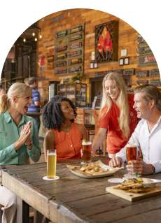 Three professionals, two female and one male, being served appetizers and beer at Fireforge in Greenville, SC.