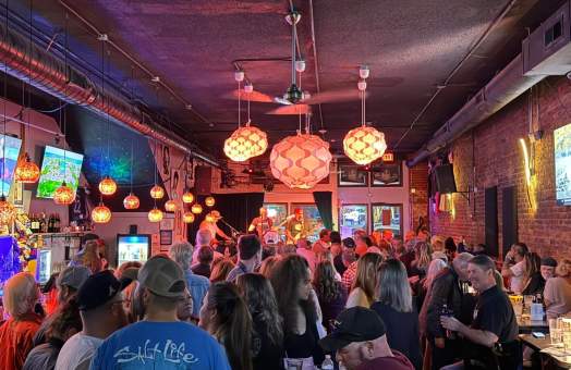 Interior of Smiley's on the Roxx with funky paper lanterns hanging above the crowd at a local live music night.