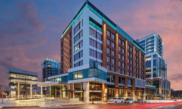 Street view of the exterior of the AC Hotel in downtown Greenville at dusk.