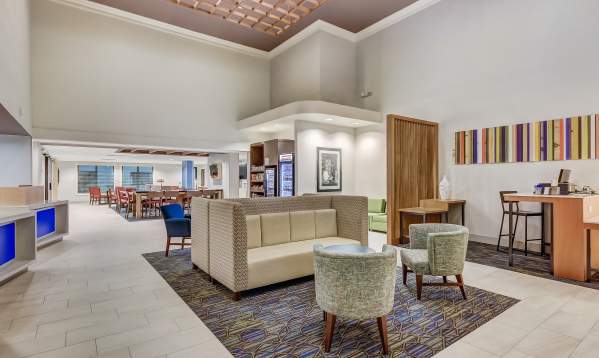A bright and inviting lobby at the Holiday Inn Express & Suites – Greenville Airport, with comfortable seating areas and contemporary design elements.