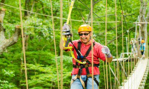 Man crossing a bridge at Green River Adventures in Saluda, NC.