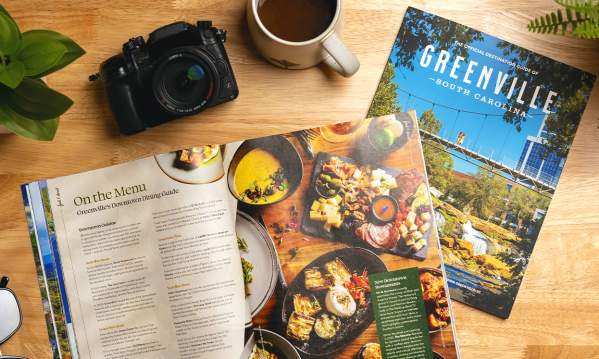 The 2025 Destination Guide splays open to an article on Downtown Dining in Greenville, SC.
