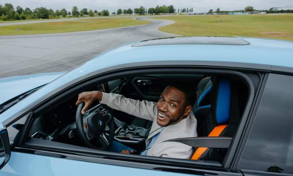 A man smiles happily driving a BMW as part of the BMW Performance Drive at the BMW Performance Center in Greer, SC.