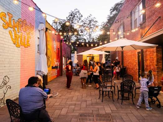 Crowds enjoy outdoor dining near murals in downtown Simpsonville, SC.