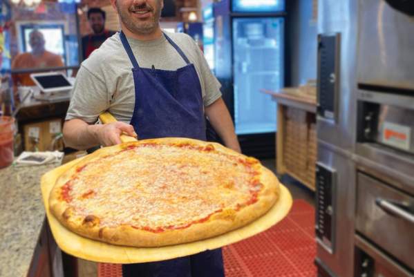 A man holding a cheese pizza