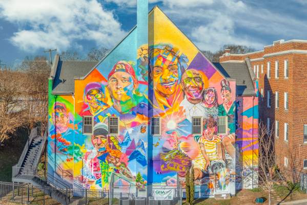 Aerial view of a building with a stunning, bright and colorful mural featuring the faces of eight Greenvillians that experienced homelessness.