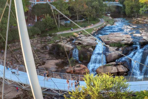 Liberty bridge with a view of the falls and the Greenville skyline.